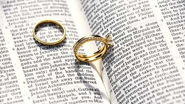 A pair of wedding rings photographed close up on a plain surface