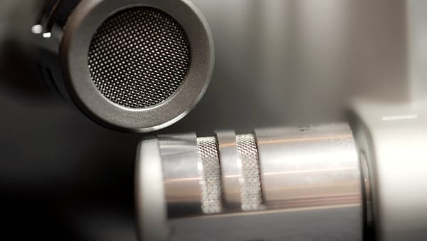 A studio microphone standing on a desk beside recording equipment