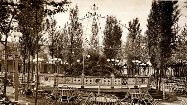 An empty restaurant terrace with chairs tipped forward onto the tables