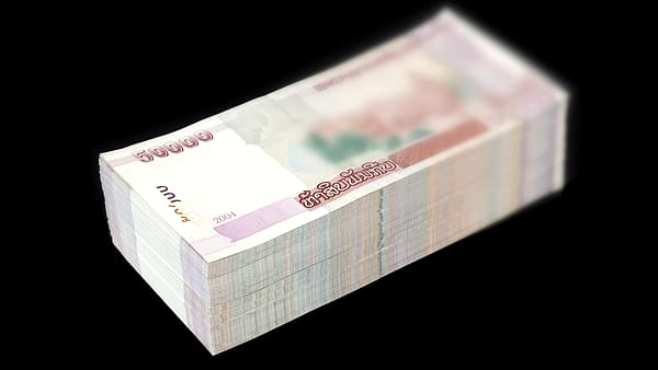 A thick stack of banknotes bound together on a dark background
