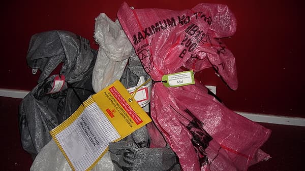 A heap of canvas mail sacks stacked against one another in a sorting area