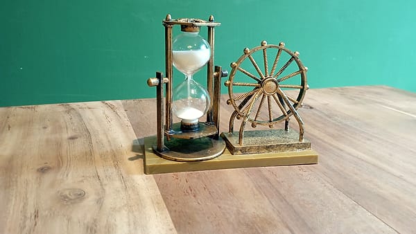 An hourglass standing on a flat surface with its sand part run through