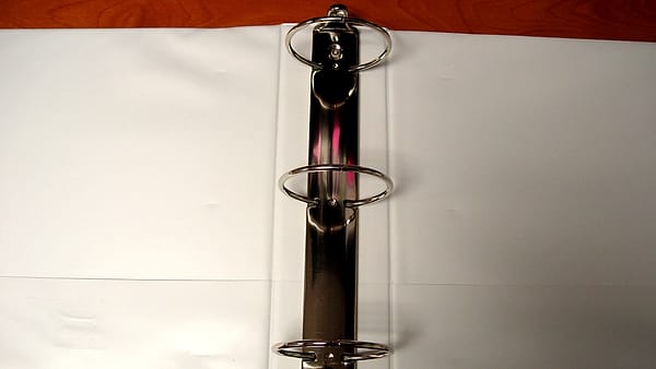 An open three-ring binder with dividers separating the sections