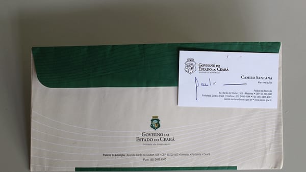 A sealed printed envelope lying unopened on a flat wooden surface