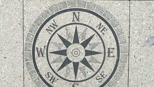 A compass rose set into a stone surface, its points marked around the circle