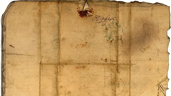 A bundle of old handwritten letters tied together on a surface