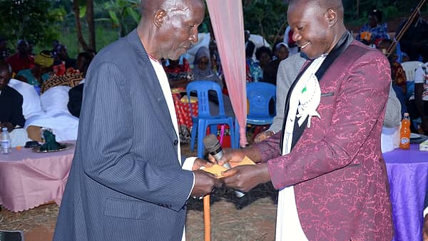 Money being handed over in an envelope at a family gathering