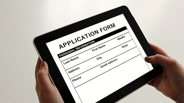 A printed application form filled in and lying flat on a table