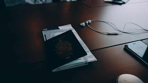 Travel documents and papers spread across a desk beside a passport