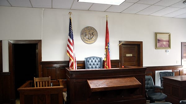 The judge's bench and witness stand inside a county courthouse courtroom
