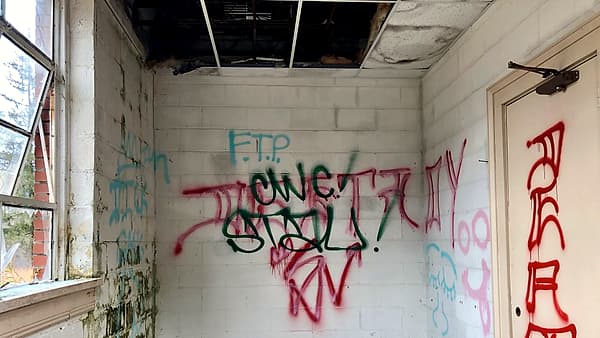 An emptied storage closet with bare shelves and an open door