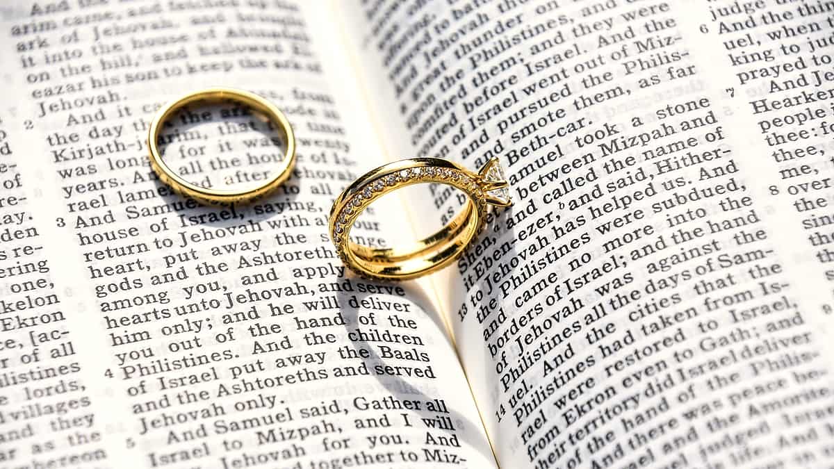 A pair of wedding rings photographed close up on a plain surface