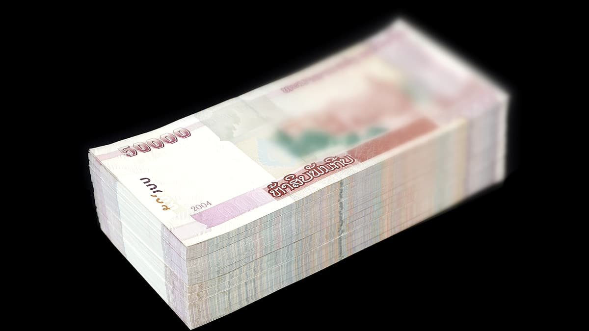 A thick stack of banknotes bound together on a dark background