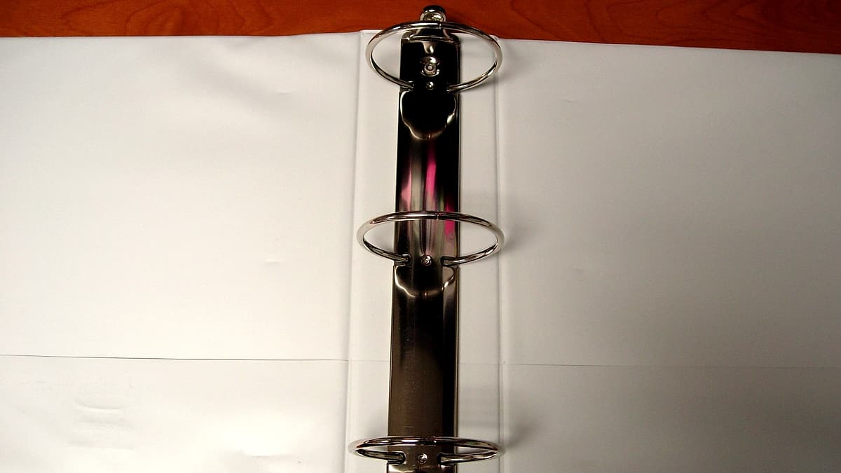 An open three-ring binder with dividers separating the sections