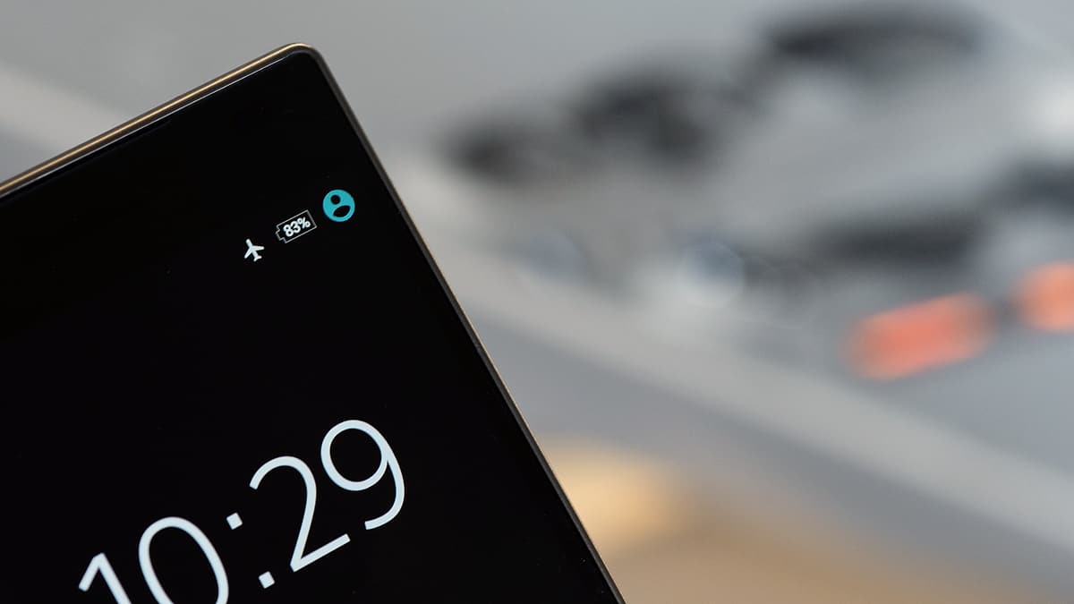 A smartphone held in one hand with its display lit against a dark background