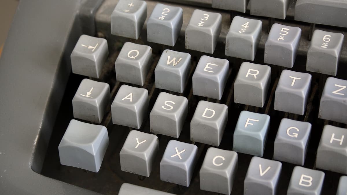 The keys of a manual typewriter photographed close up, the letters worn with use