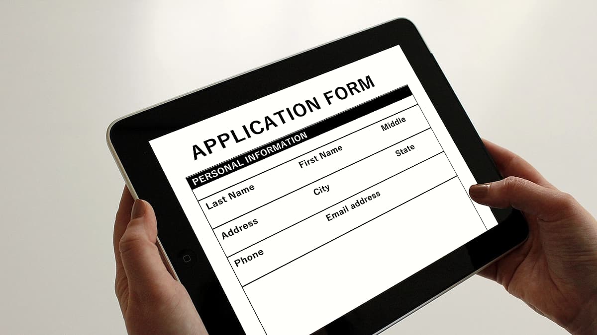 A printed application form filled in and lying flat on a table