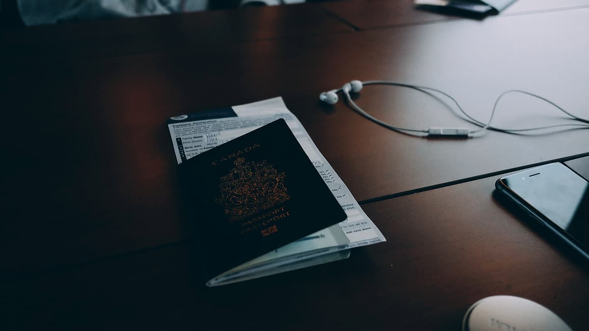 Travel documents and papers spread across a desk beside a passport