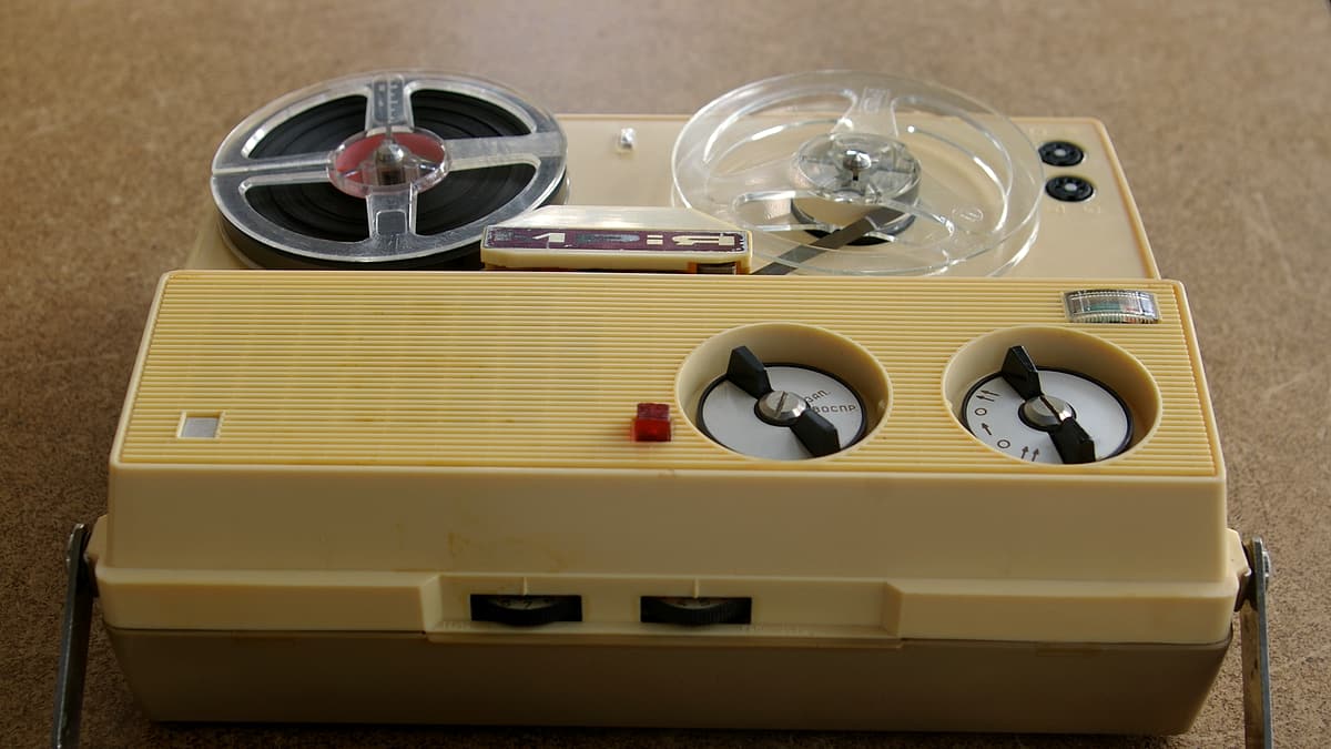 A portable reel-to-reel tape recorder standing on a flat surface